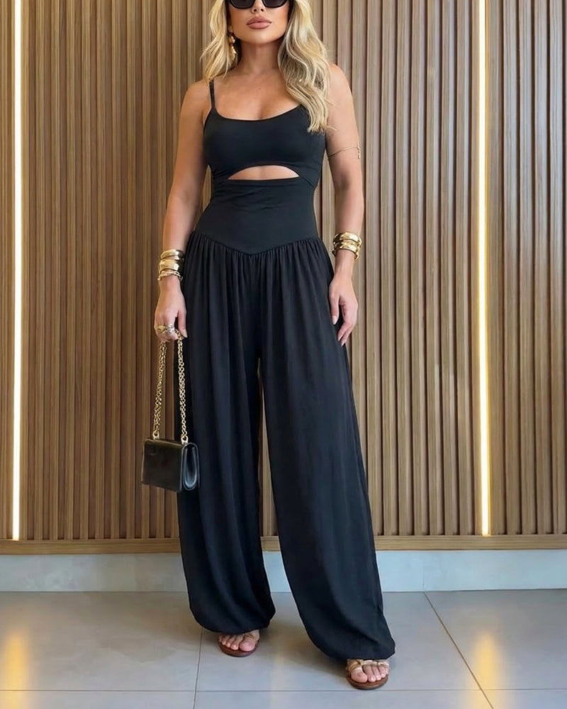 Backless black jumpsuit with cut-out waist and tie-back detail, featuring a stylish lantern silhouette. 0