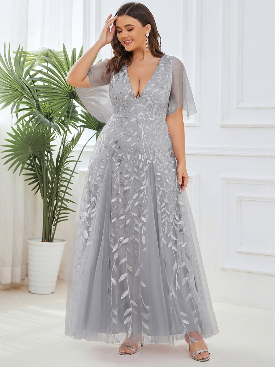 Plus size evening gown with a deep V-neck and a sequinned leaf pattern over tulle.