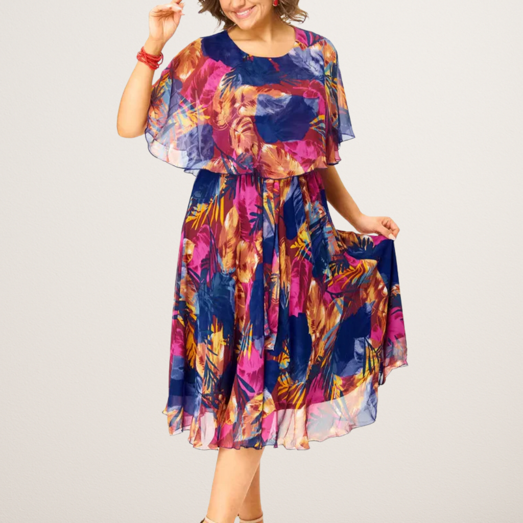 A flowing plus-size summer dress in a vibrant floral pattern with shades of blue and pink, featuring short sleeves. 1