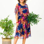 A flowing plus-size summer dress in a vibrant floral pattern with shades of blue and pink, featuring short sleeves. 3
