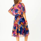 A flowing plus-size summer dress in a vibrant floral pattern with shades of blue and pink, featuring short sleeves. 4