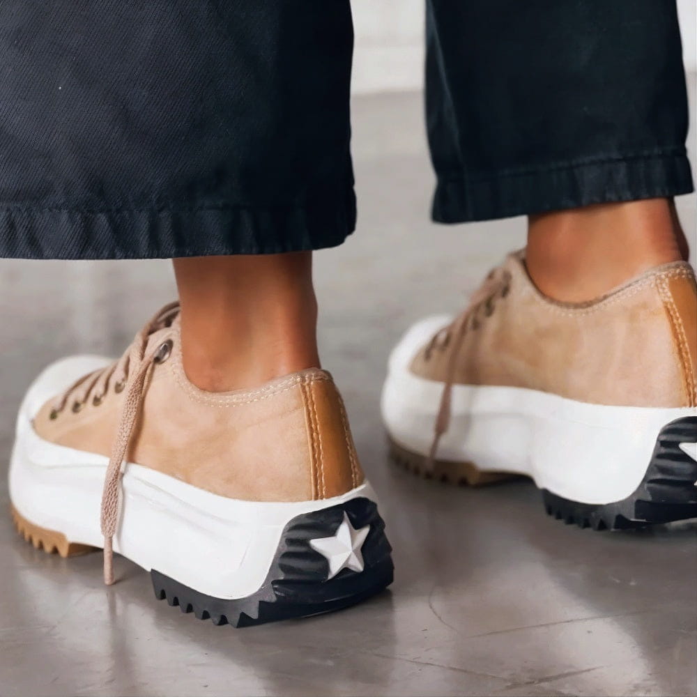 White platform sneakers with a sleek, minimalist design and subtle textured accents. 1