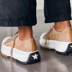 White platform sneakers with a sleek, minimalist design and subtle textured accents. 1
