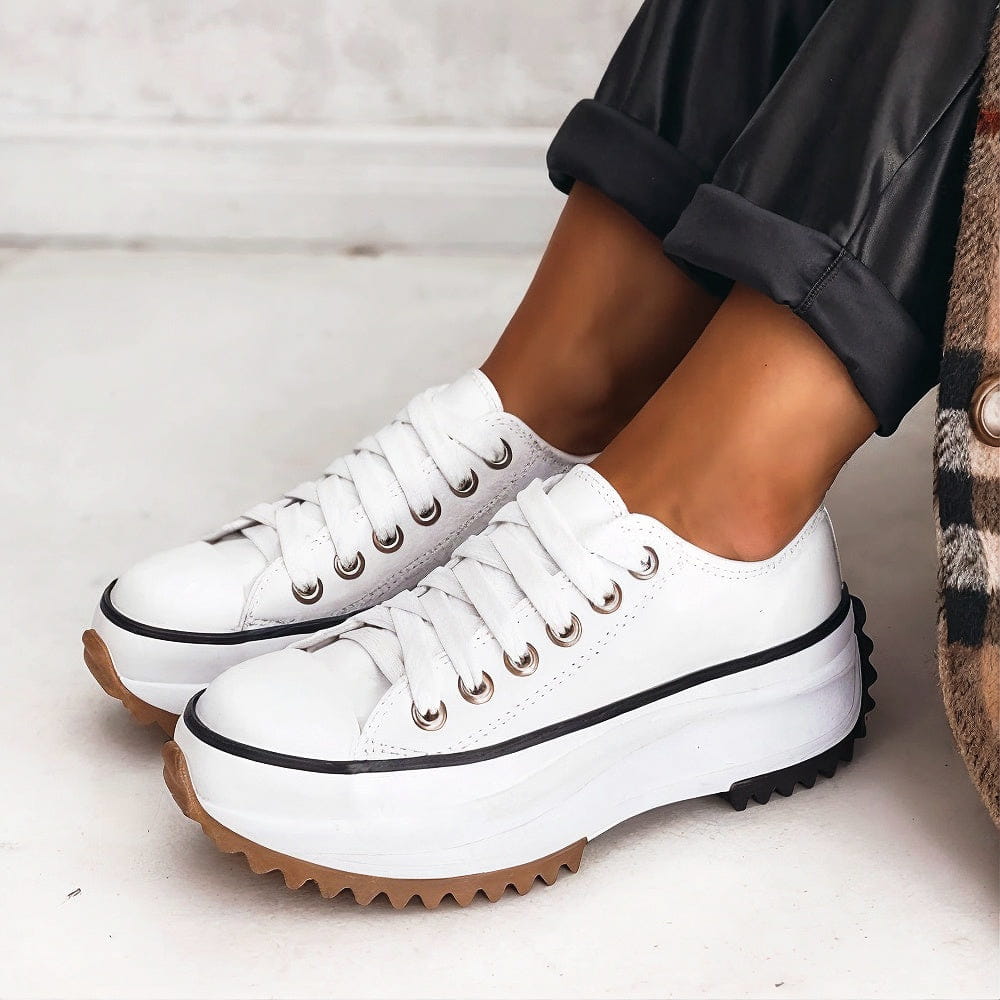 White platform sneakers with a sleek, minimalist design and subtle textured accents. 3