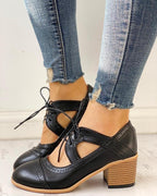 Black heeled T-strap shoes with a sleek design and elegant silhouette. 0