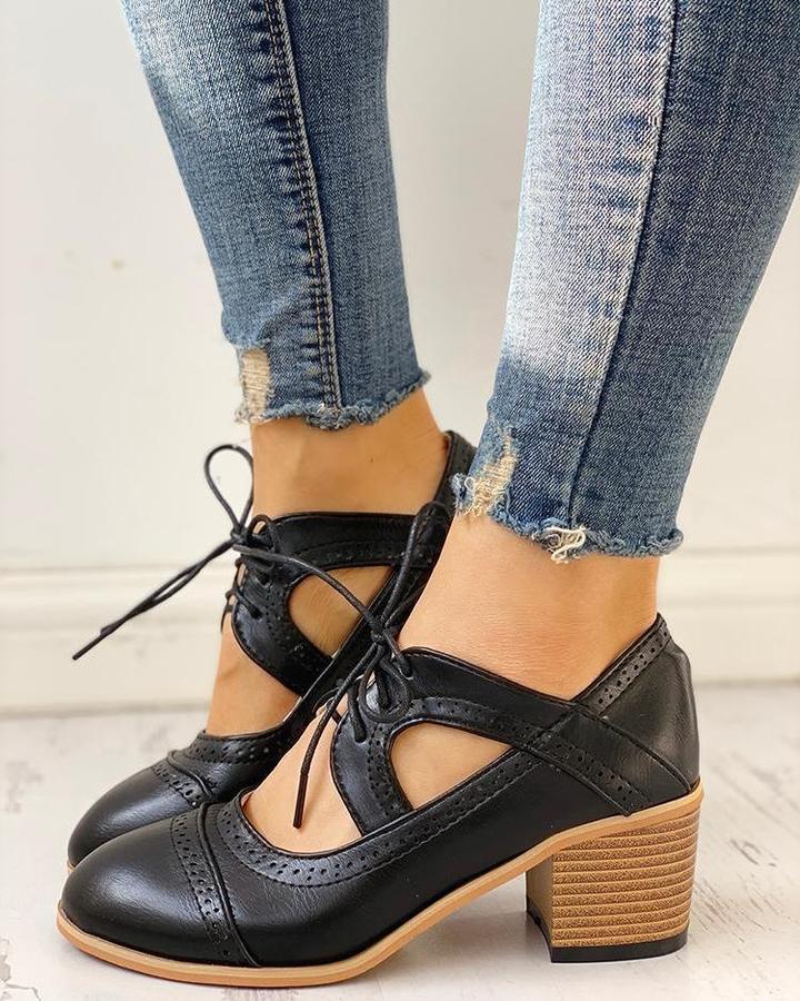 Black heeled T-strap shoes with a sleek design and elegant silhouette. 0
