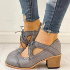 Black heeled T-strap shoes with a sleek design and elegant silhouette. 1