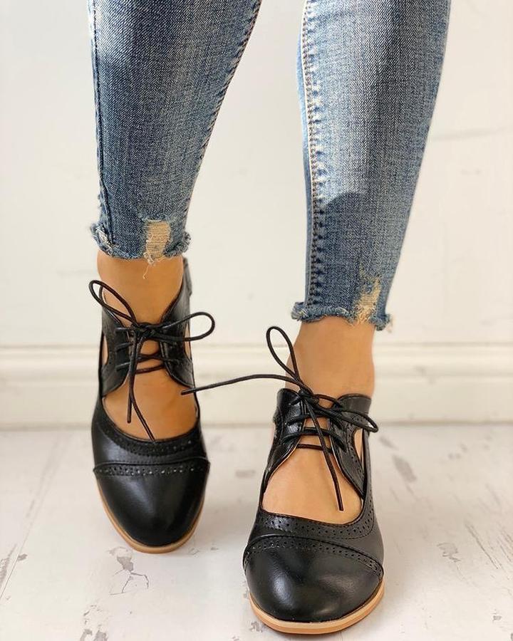 Black heeled T-strap shoes with a sleek design and elegant silhouette. 3