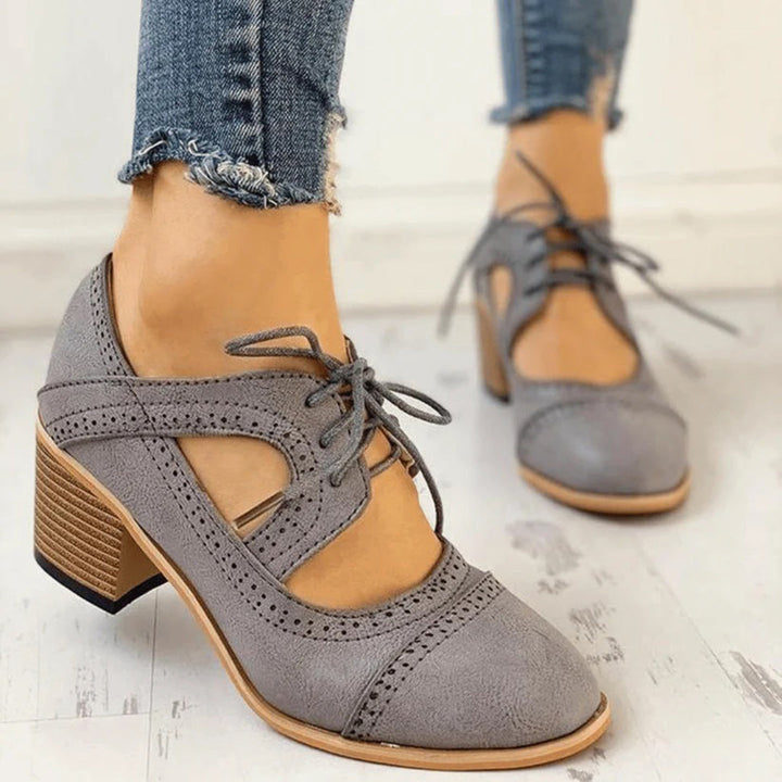 Black heeled T-strap shoes with a sleek design and elegant silhouette. 4