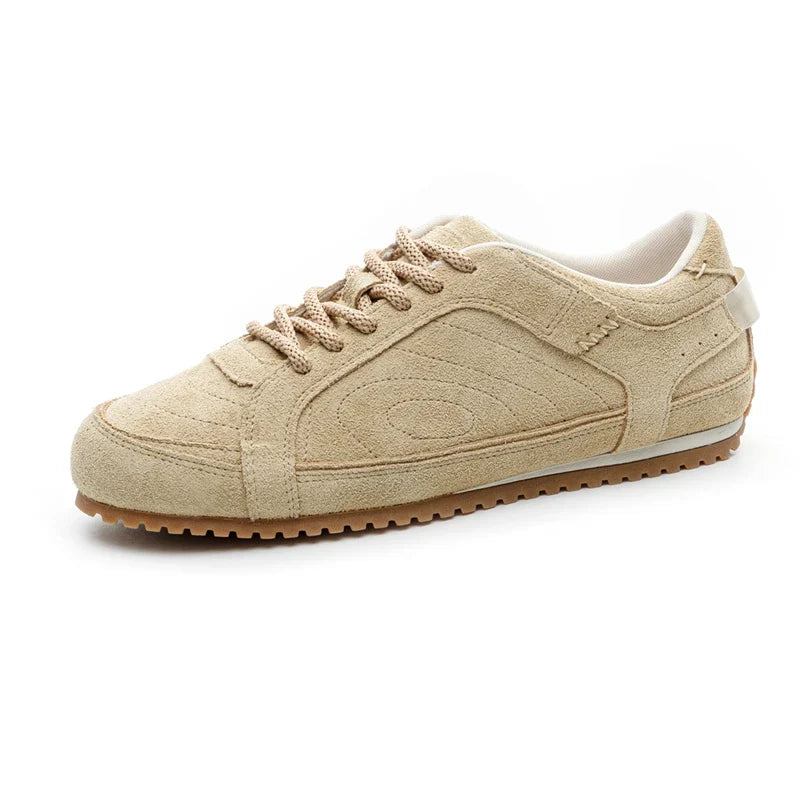 White leather trainers with a sleek, minimalist design and subtle perforations for breathability. 2