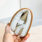 White leather trainers with a sleek, minimalist design and subtle perforations for breathability. 7
