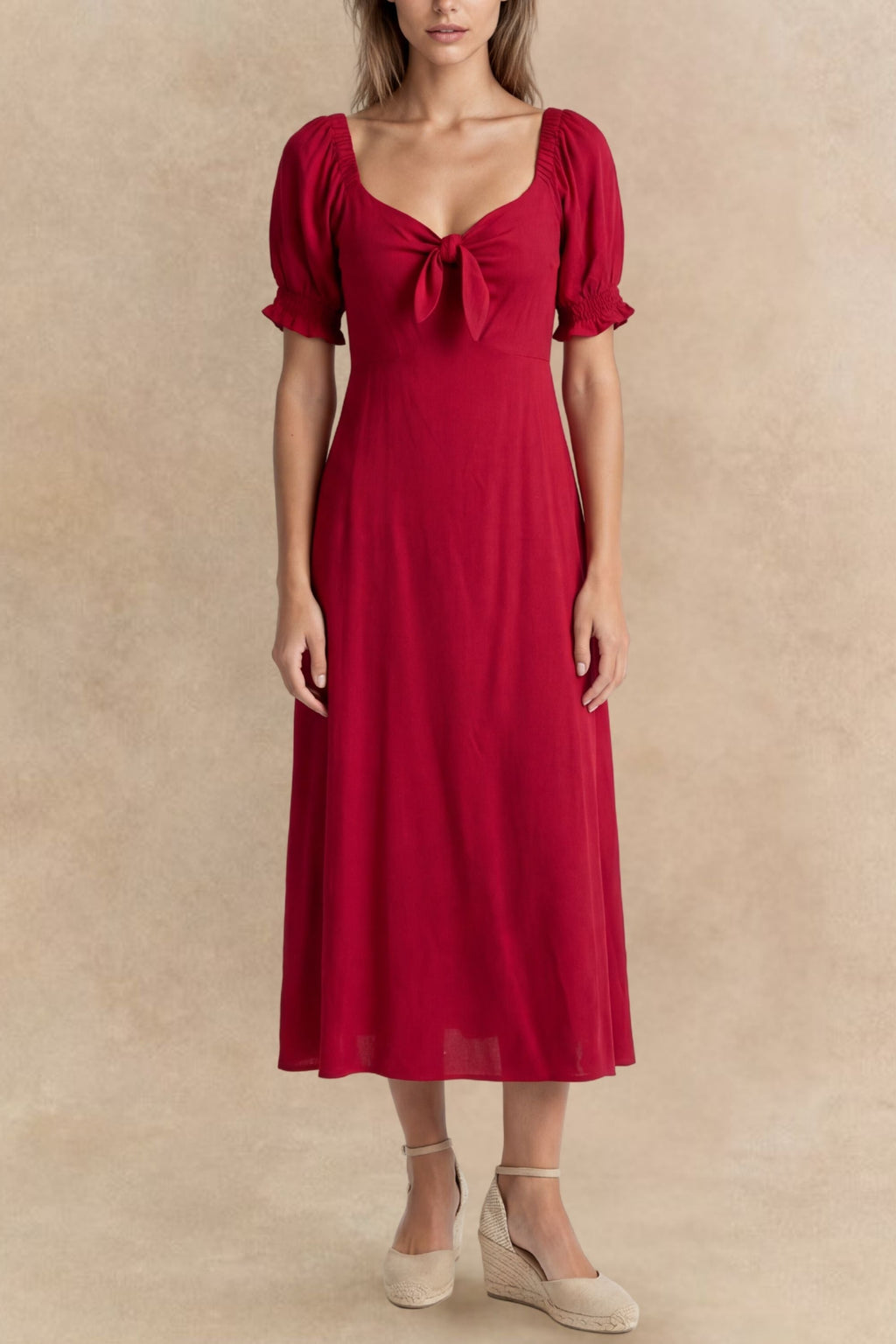 A green fit and flare midi dress with short sleeves and a front tie detail. 1