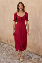 A green fit and flare midi dress with short sleeves and a front tie detail. 4