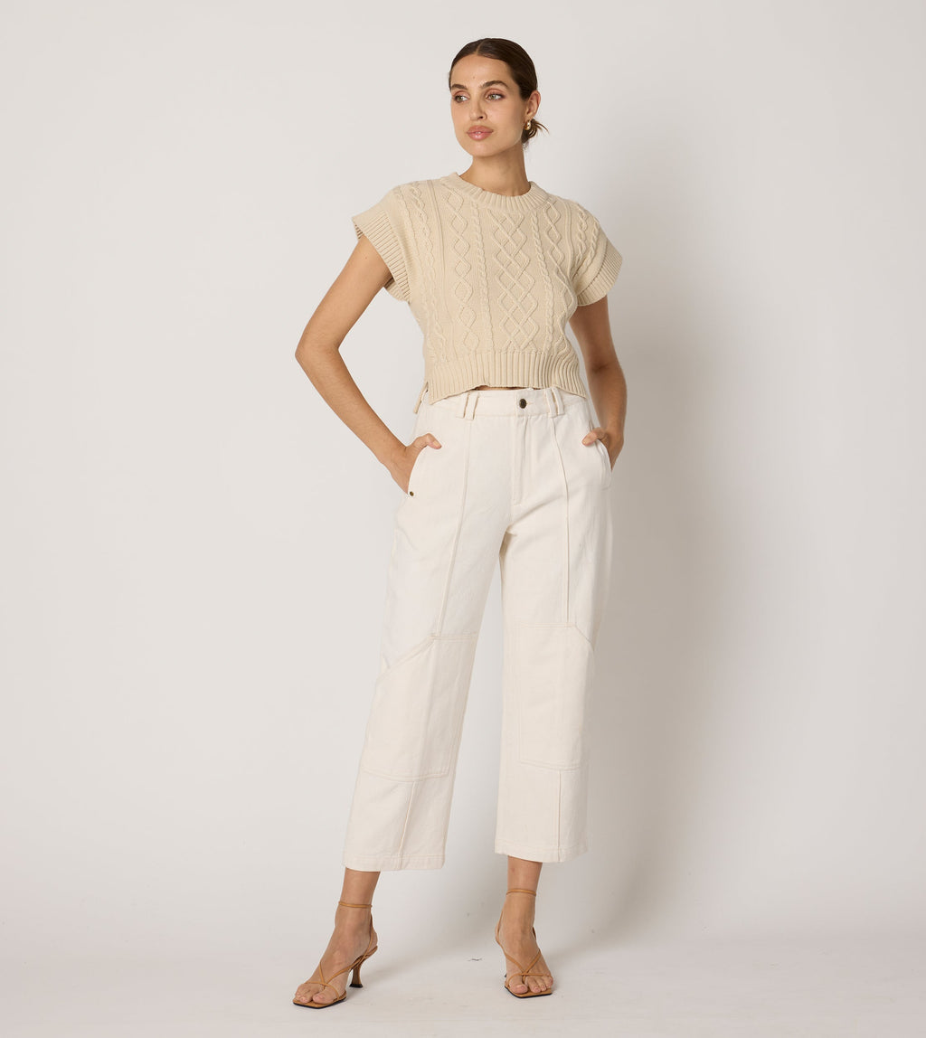 Cream cropped sweater vest in a cozy cable knit style, made from organic cotton for a soft, textured look. 1