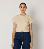 Cream cropped sweater vest in a cozy cable knit style, made from organic cotton for a soft, textured look. 2