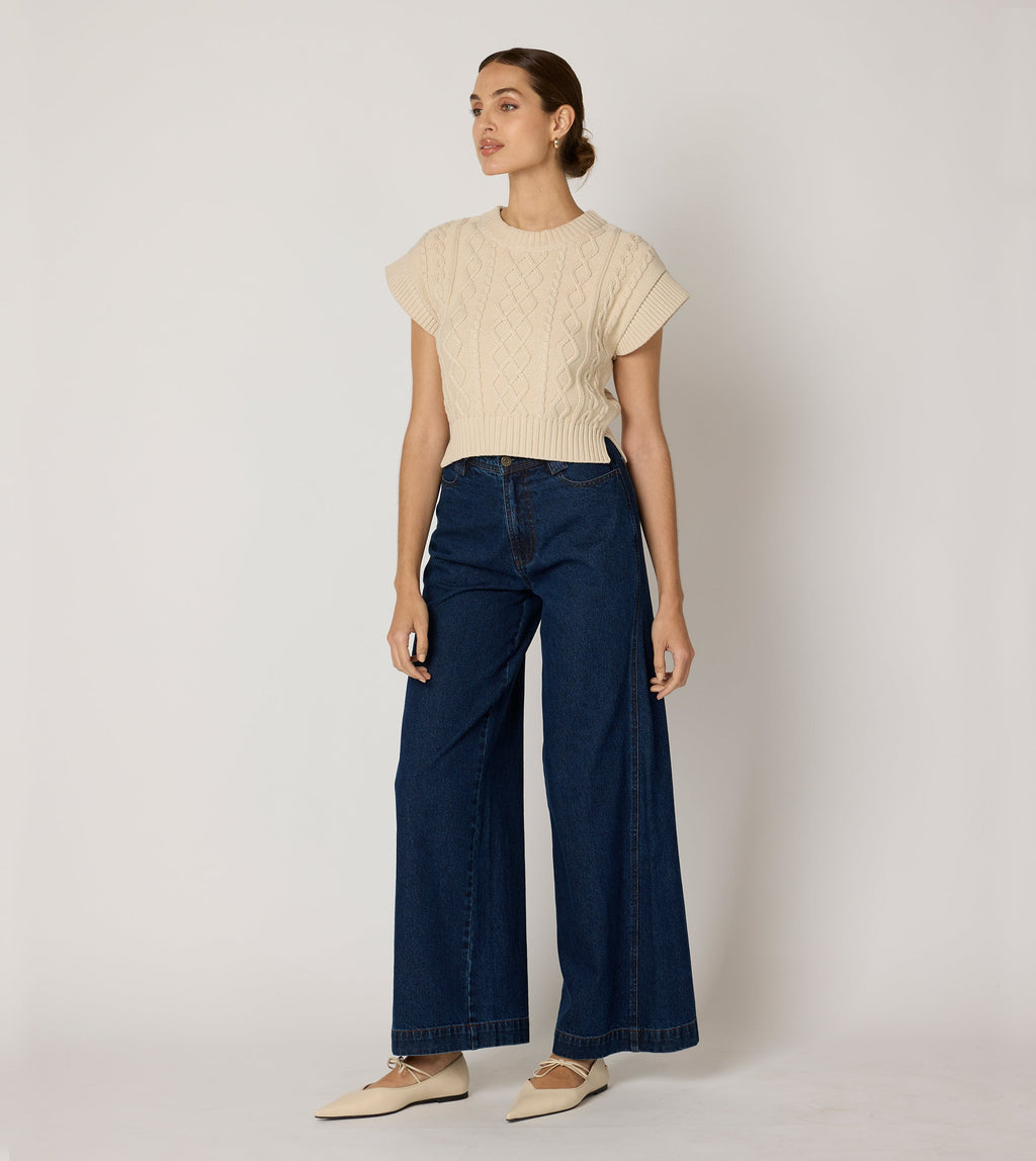Cream cropped sweater vest in a cozy cable knit style, made from organic cotton for a soft, textured look. 4