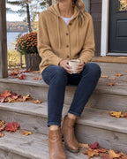 Greta hooded knit cardigan with wooden buttons, camel, worn seated outdoors