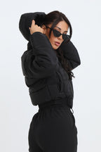 Black cropped padded jacket with long sleeves and zip front, featuring a modern and casual style. 3