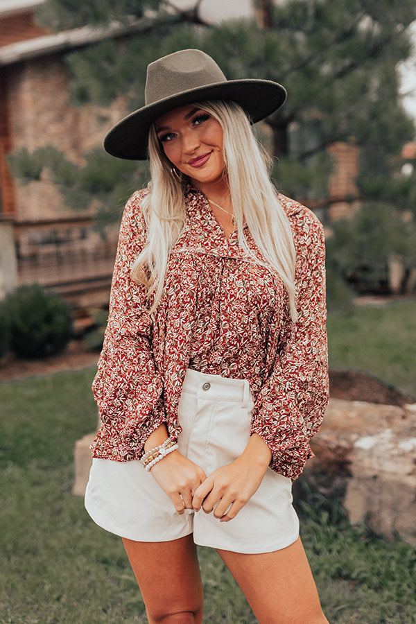 Rust floral babydoll top with a V-cut neckline and long sleeves, featuring a relaxed and feminine style. 1