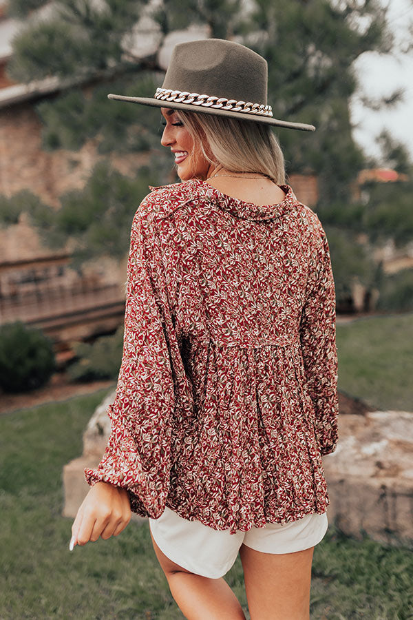 Rust floral babydoll top with a V-cut neckline and long sleeves, featuring a relaxed and feminine style. 2