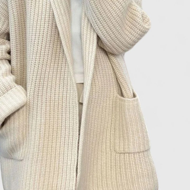 Longline ribbed cardigan for women with a shawl collar and deep patch pockets.