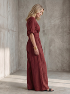 Lila wide leg jumpsuit in deep violet with a cross front and elbow-length sleeves, featuring a chic and elegant style. 8