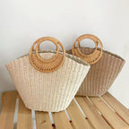 Lila woven straw tote bag in natural tones with wooden handles, perfect for carrying beach essentials. 4