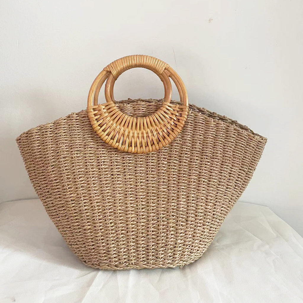 Lila woven straw tote bag in natural tones with wooden handles, perfect for carrying beach essentials. 5