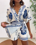 Light blue women's romper featuring a starfish and seashell print, designed with batwing sleeves for a relaxed fit. 0