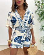 Light blue women's romper featuring a starfish and seashell print, designed with batwing sleeves for a relaxed fit. 2