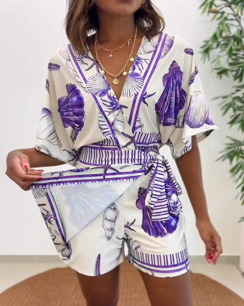 Light blue women's romper featuring a starfish and seashell print, designed with batwing sleeves for a relaxed fit. 7