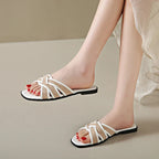 Tan woven flat slides with a casual, bohemian style perfect for relaxed summer outings. 1