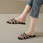 Tan woven flat slides with a casual, bohemian style perfect for relaxed summer outings. 2