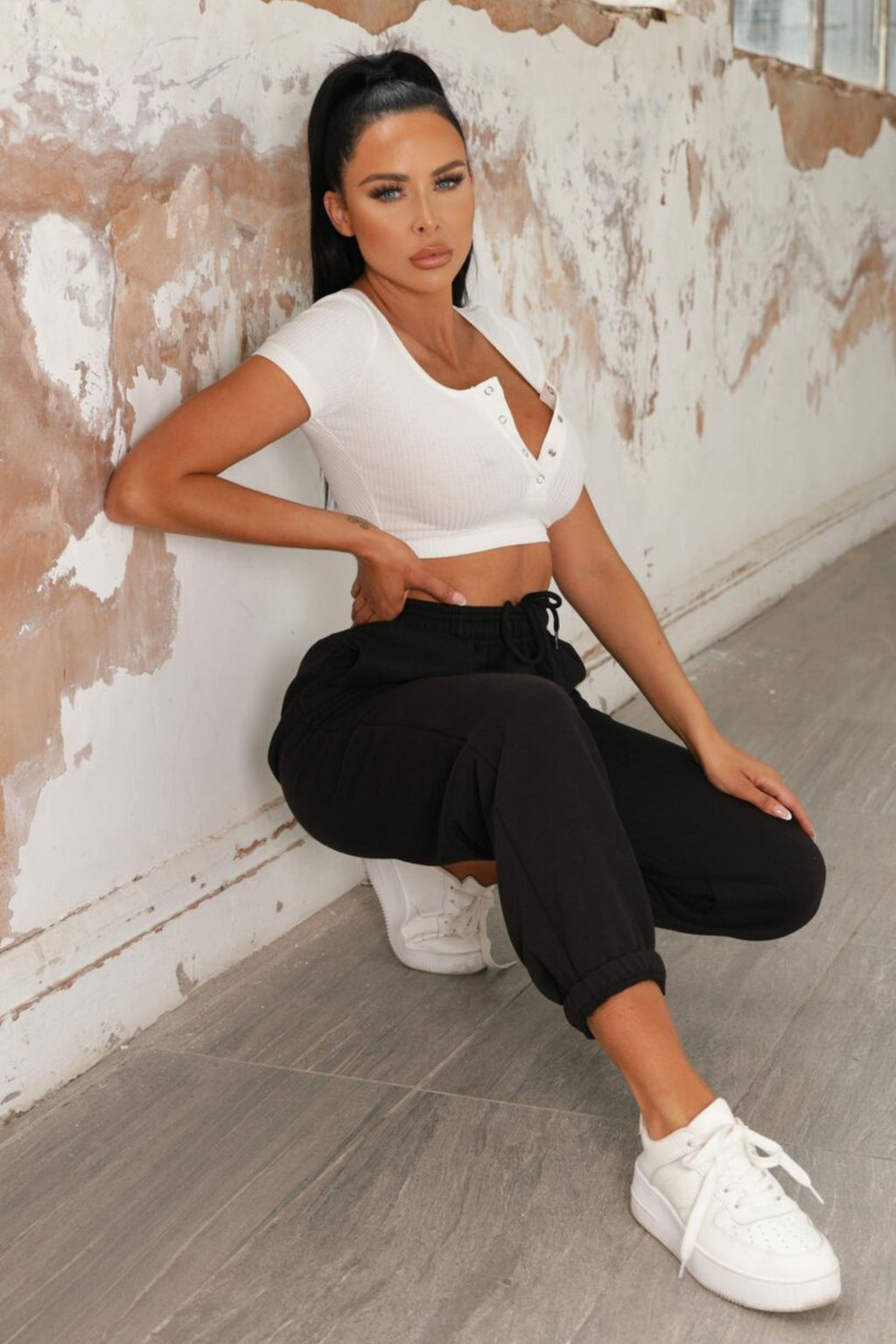 Black joggers with cuffed hems and an elasticated waist, featuring a relaxed and casual style. 2