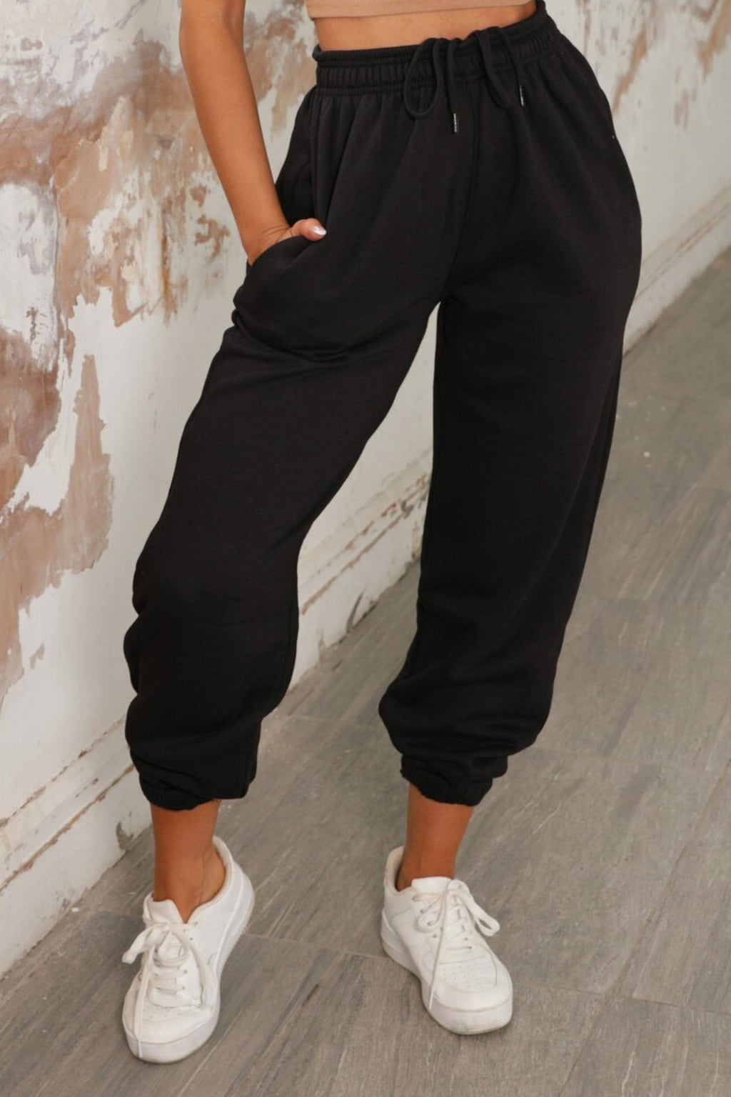 Black joggers with cuffed hems and an elasticated waist, featuring a relaxed and casual style. 5