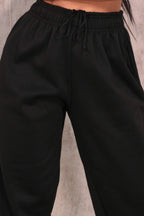 Black joggers with cuffed hems and an elasticated waist, featuring a relaxed and casual style. 6