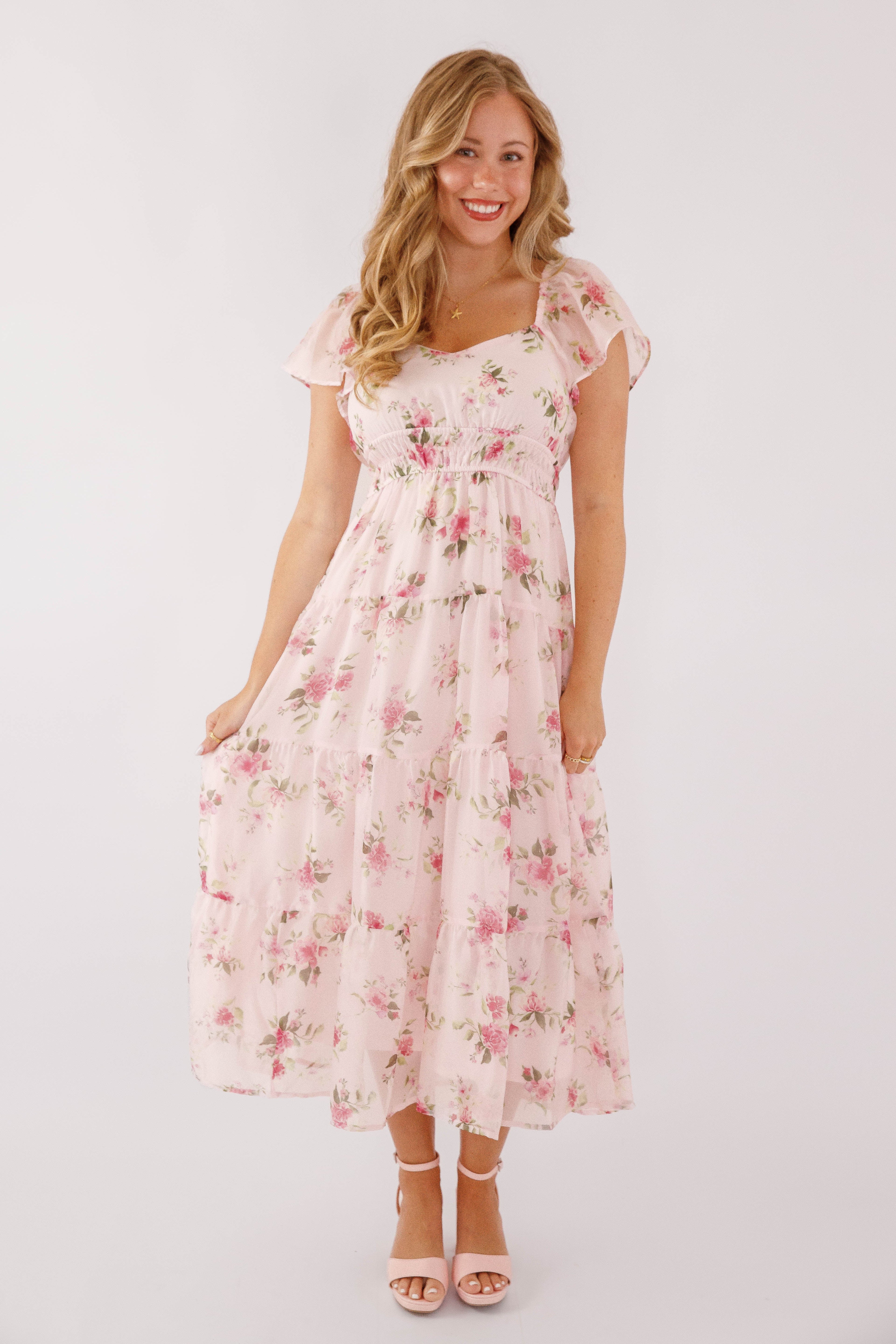 Blush pink midi dress with a floral pattern and flutter sleeves, perfect for wedding guests. 1