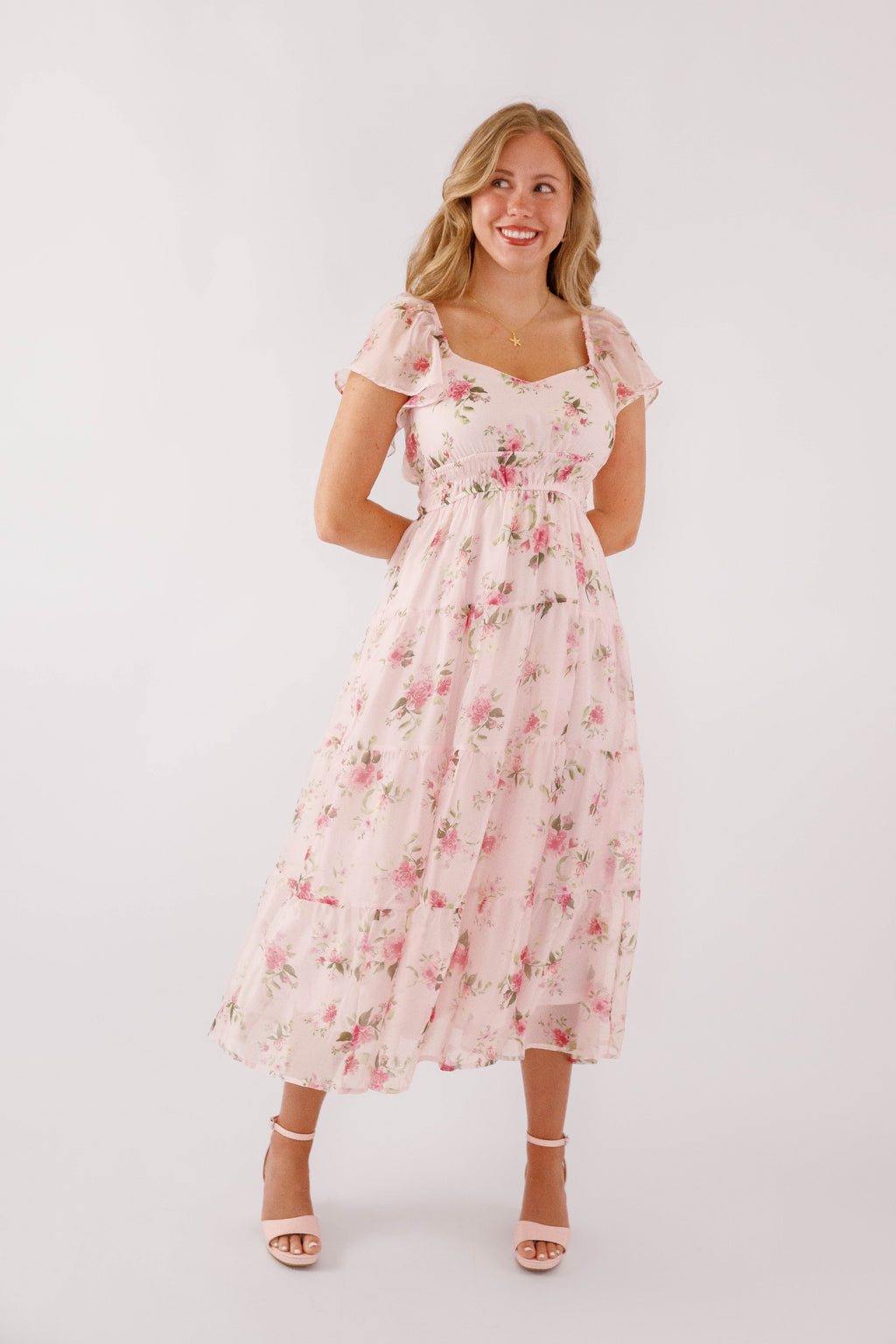 Blush pink midi dress with a floral pattern and flutter sleeves, perfect for wedding guests. 5