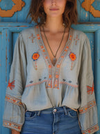 Flowy white bohemian blouse with delicate lace details and vibrant floral patterns. 0