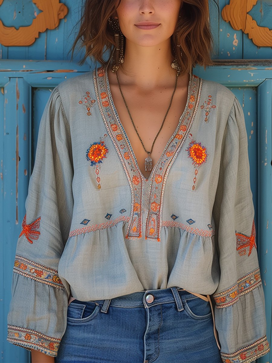 Flowy white bohemian blouse with delicate lace details and vibrant floral patterns. 0