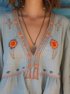 Flowy white bohemian blouse with delicate lace details and vibrant floral patterns. 1