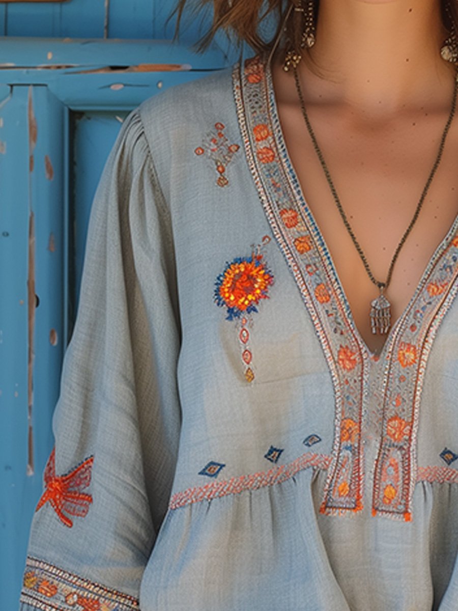 Flowy white bohemian blouse with delicate lace details and vibrant floral patterns. 2