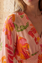 Flowy pink floral maxi dress with a V-neckline and long sleeves, featuring a smocked bodice for a relaxed fit. 2