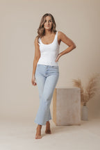 A white scoop neck tank top made of double-lined jersey fabric, offering a simple and classic style. 3