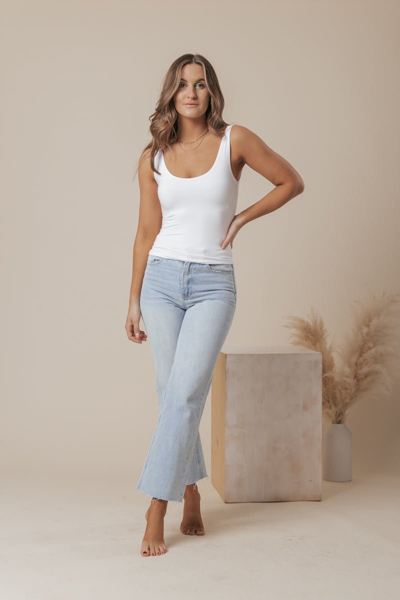 A white scoop neck tank top made of double-lined jersey fabric, offering a simple and classic style. 3