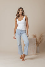 A white scoop neck tank top made of double-lined jersey fabric, offering a simple and classic style. 4