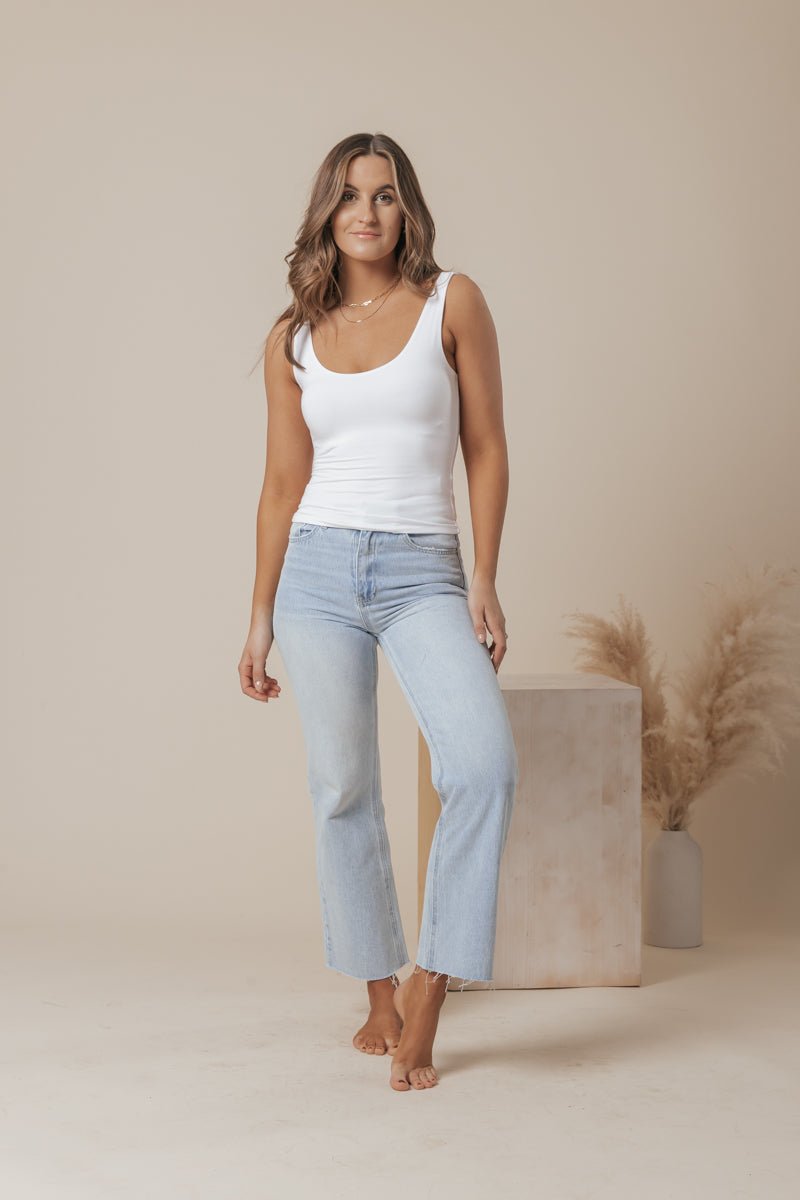A white scoop neck tank top made of double-lined jersey fabric, offering a simple and classic style. 4