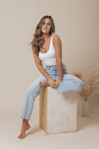 A white scoop neck tank top made of double-lined jersey fabric, offering a simple and classic style. 5