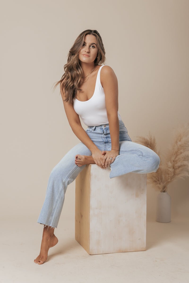A white scoop neck tank top made of double-lined jersey fabric, offering a simple and classic style. 5