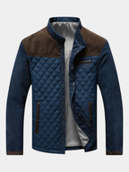Men's quilted jacket with contrast corduroy shoulder panels and a stand collar.